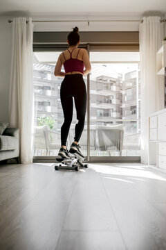 Woman exercising at home on a step machine