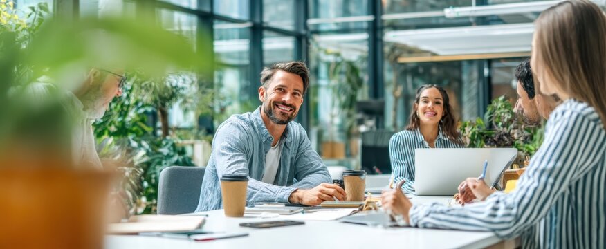 The cheerful team gathers for a productive brainstorming session in a modern office.
