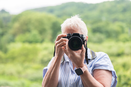 Elderly woman capturing nature through her camera lens