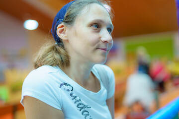 Woman smiles while participating in an indoor community activity at a local event space