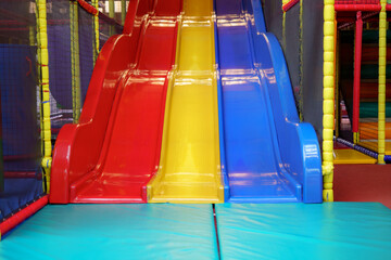 Brightly colored slides in a children's indoor play area invite fun and excitement for kids of all ages