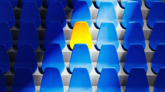 Bright yellow stadium seat stands out among blue chairs in isolation