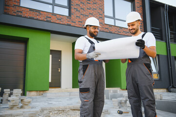 Pleased contractor demonstrating cottage facade to construction manager