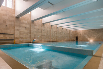 Swimming pool in a spacious room of a private house. The pool is divided into two parts: one for swimmers and the second small for taking water procedures.