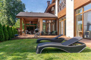 Private territory of a luxurious mansion in the half-timbered style. Lawn with sun beds, barbecue...