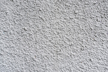 Rough white textured wall provides a detailed closeup of its uneven surface, suitable for...
