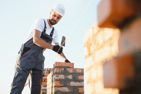 Construction worker in uniform and safety equipment have job on building. Industrial theme