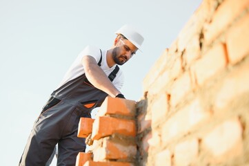 Construction worker in uniform and safety equipment have job on building. Industrial theme