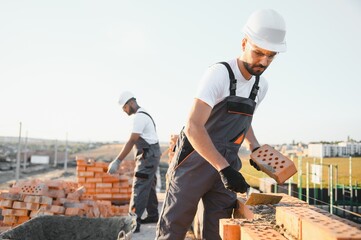 Construction worker in uniform and safety equipment have job on building. Industrial theme