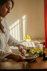 Young woman preparing a lemon cake, mixing ingredients on a rustic table with natural light,...
