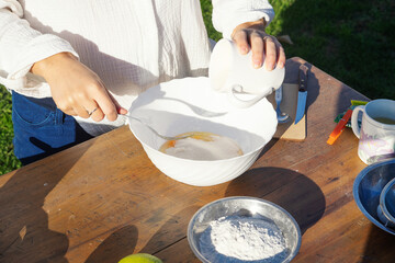 Girl baking a lemon cake, following the steps on her phone, mixing ingredients in a bowl on a...
