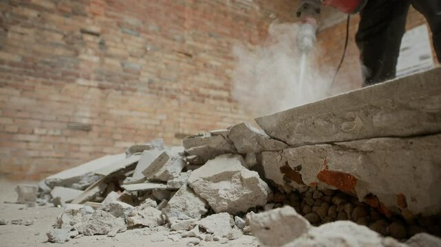 Cropped shot of unrecognizable male construction worker destroying floor with jackhammer on site
