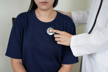 An asian doctor in hospital provides medical care and consultations, diagnosing and treating patient using stethoscopes, prescriptions, and checking blood pressure with digital blood pressure monitor.