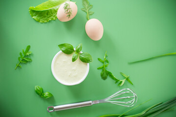 Top view of homemade mayonnaise with green herbs and eggs
