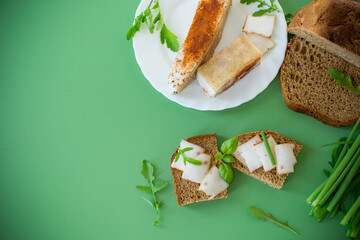 Traditional Ukrainian dish with lard and greens on a green background