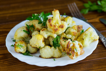 Appetizing fried cauliflower on a dark kitchen surface