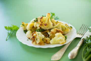 Rustic vegetable dish with cabbage and herbs on a green background