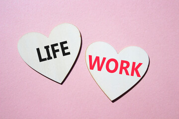 Life or Work symbol. Concept word Life or Work on wooden hearts. Beautiful pink background. Business and Life or Work concept. Copy space