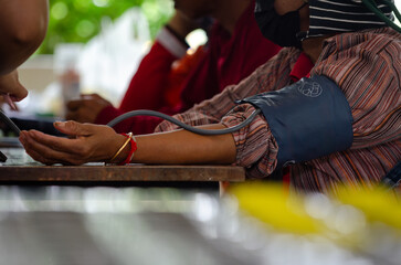 Annual checkup concept. Doctor is measuring patient's blood pressure. The patient has a blood pressure cuff on his arm.