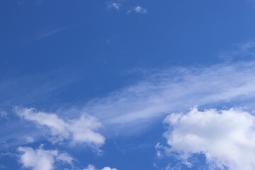 White clouds against the blue sky. Sky background. Summer. Landscape. Soft white clouds against the blue sky. Calm and serene atmosphere. White fluffy clouds