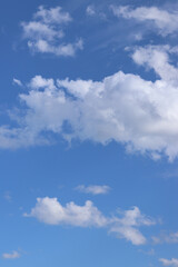 White clouds against the blue sky. Sky background. Summer. Landscape. Soft white clouds against the blue sky. Calm and serene atmosphere. White fluffy clouds