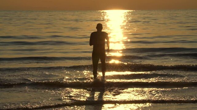 a man is running into the sea