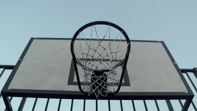 Basketball flies straight towards basket, but it hits backboard and bounces off. It is an unfortunate mistake by the streetball team. Slow motion. below