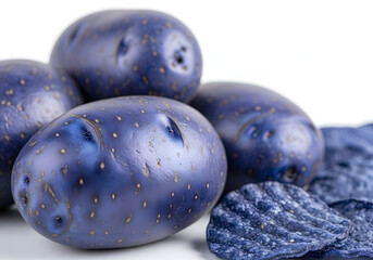 A close-up of vibrant blue potatoes and blue potato chips arranged together. The glossy surface of the potatoes contrasts with the textured chips, creating an appealing visual.