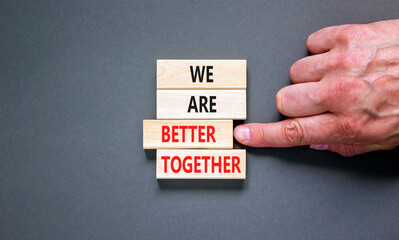 We are better together symbol. Concept words phrase We are better together on beautiful wooden blocks. Beautiful grey background. Businessman hand. Business We are better together concept. Copy space.