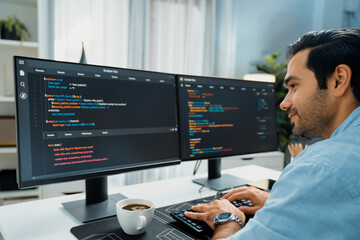 Concentrating in smart IT developer working software development coding on two pc screen, creating...