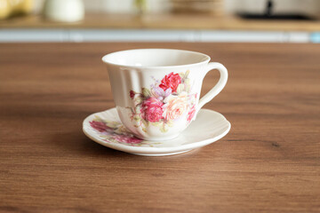 Beautiful white cup with flowers in the kitchen