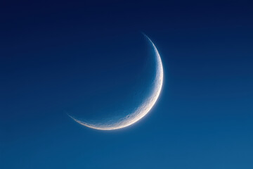 A crescent moon against the clear blue sky