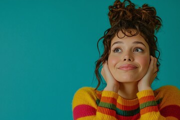 Woman Smiling With Curly Hair In A Colorful Sweater Against A Teal Background