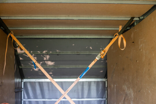 Interior view of a cargo hold with tie-down straps stretched between the walls and ceiling to secure cargo