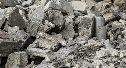 Pile of concrete debris with exposed rebar and pipes after building demolition