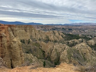 Eroded sandstone cliffs and valleys with scattered vegetation
