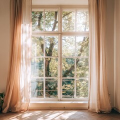 Fototapeta premium Sunlight streams through sheer curtains, illuminating a large window with a view of leafy green trees outside