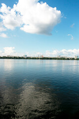Panoramic view of left bank of Dnieper River. Ukraine. The city of Dnieper. Reflection of the sky with clouds on the water surface.