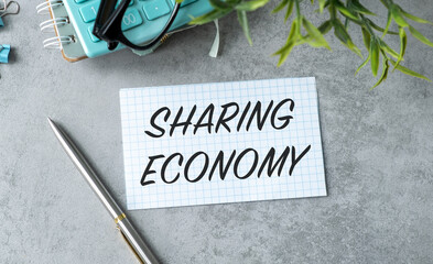 A pen is on a table with a piece of paper that says Sharing Economy