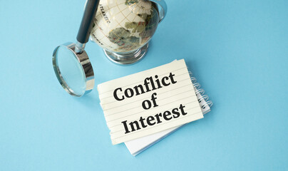 A magnifying glass is on top of a globe. A piece of paper with the word Conflict of Interest written