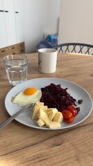 Well-balanced breakfast featuring healthy source of ptotein, fermented and fresh vegetables, salad and nuts on a plate. Top view real kitchen photo, diet and self care and love concept