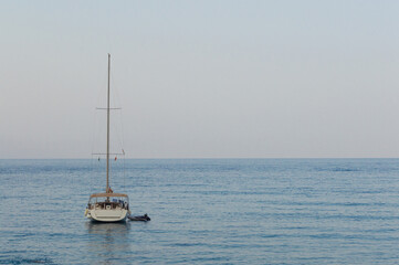 Yachting on a serene seascape at sea. A lone ship sailing on the water on a sunny summer day. Frontal view
