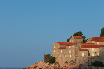 Sveti Stefan Island Hotel, stone houses of a medieval fortress village with tiled roofs on the Adriatic coast of Montenegro