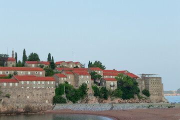 Sveti Stefan Island Hotel, stone houses of a medieval fortress village with tiled roofs on the Adriatic coast of Montenegro