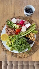 Well-balanced breakfast featuring healthy source of ptotein, fermented and fresh vegetables, salad and nuts on a plate. Top view real kitchen photo, diet and self care and love concept