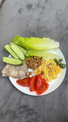 Well-balanced breakfast featuring healthy source of ptotein, fermented and fresh vegetables, salad and nuts on a plate. Top view real kitchen photo, diet and self care and love concept