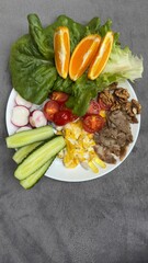 Well-balanced breakfast featuring healthy source of ptotein, fermented and fresh vegetables, salad and nuts on a plate. Top view real kitchen photo, diet and self care and love concept
