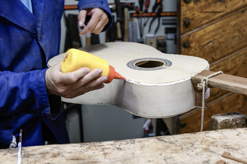 Luthier applying glue to guitar body edge before installing purfling or binding