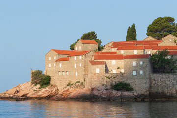 Sveti Stefan Island Hotel, stone houses of a medieval fortress village with tiled roofs on the Adriatic coast of Montenegro