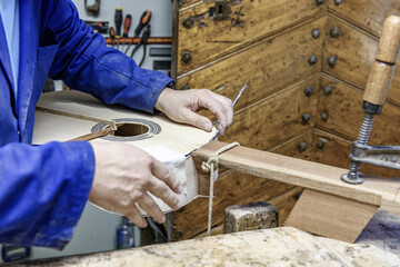 Luthier carefully installing purfling on handmade flamenco guitar body